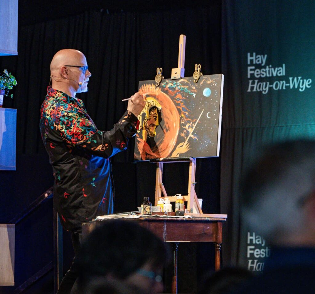 A man painting while on stage