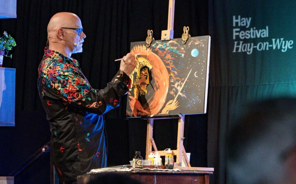 A man painting while on stage