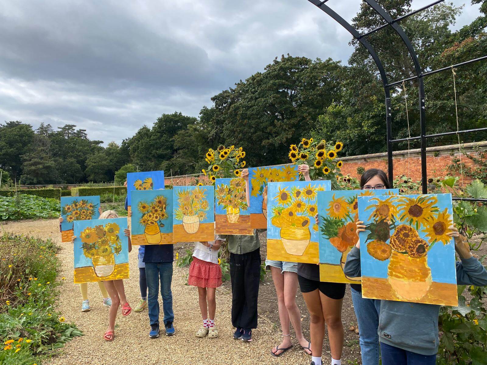 Children hold their versions of Van Gogh's sunflowers in the air