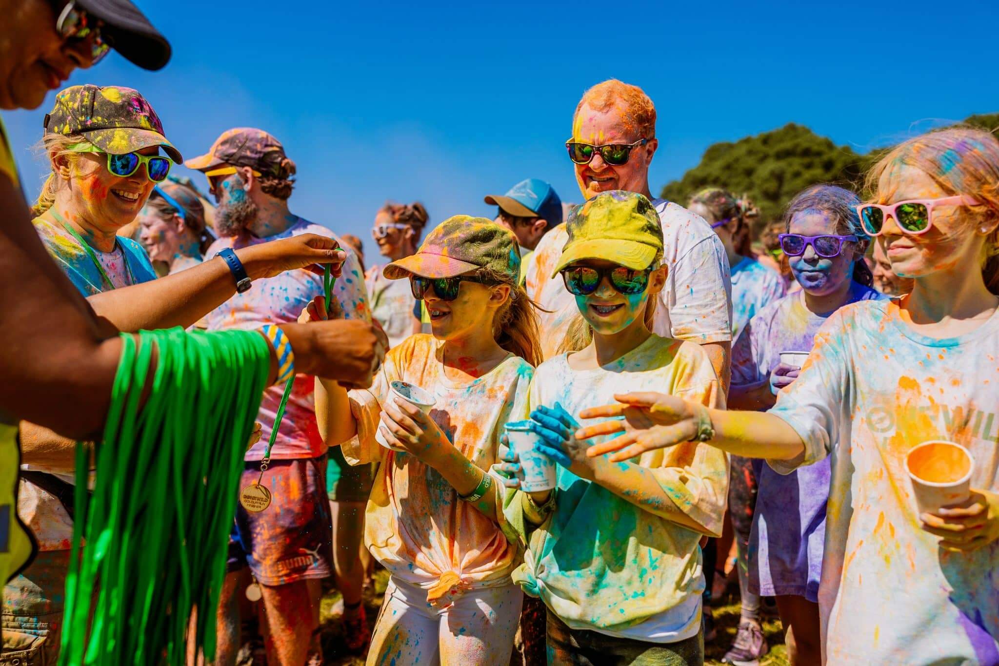 A group of people in clothing covered in powder paint in a colour run