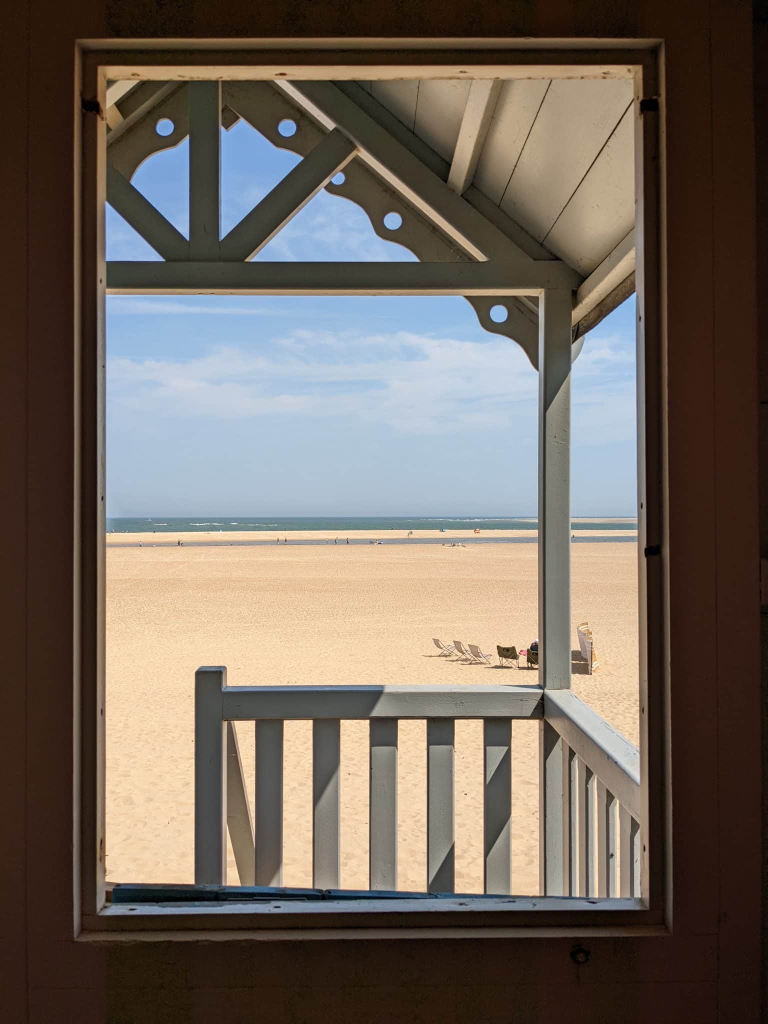 View of Wells Beach with the sea in the distance taken through a beach hut window.
