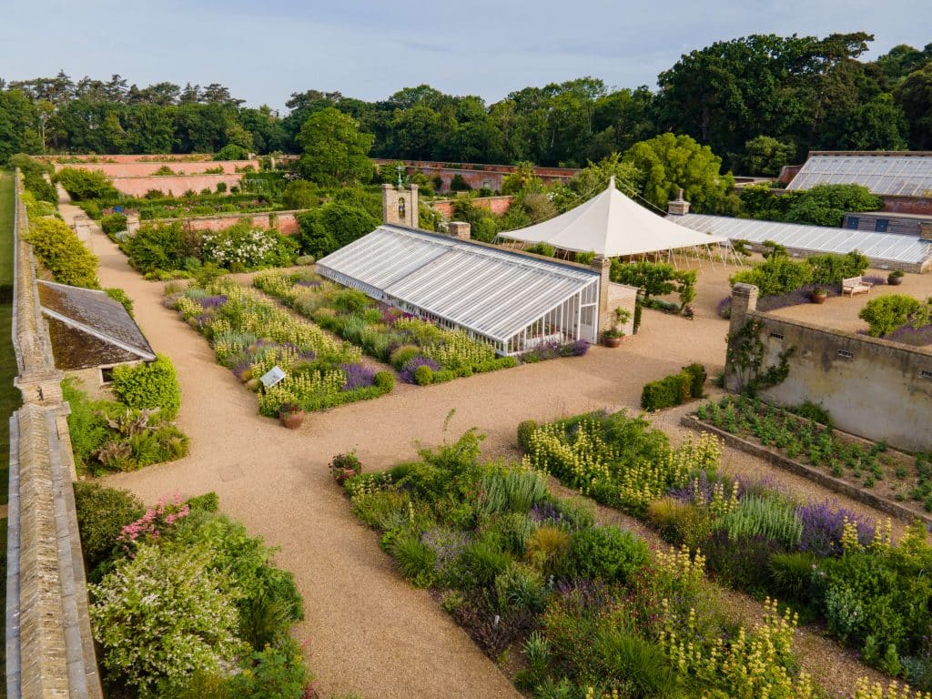 Aerial shot showing neat beds and a glasshouse in Holkham Walled Garden