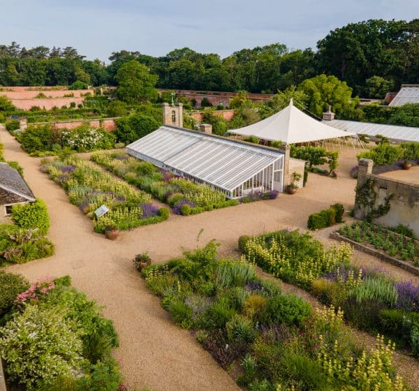 Aerial shot showing neat beds and a glasshouse in Holkham Walled Garden