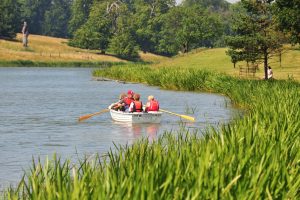 A group share a rowing boat and paddle on Holkham Lake