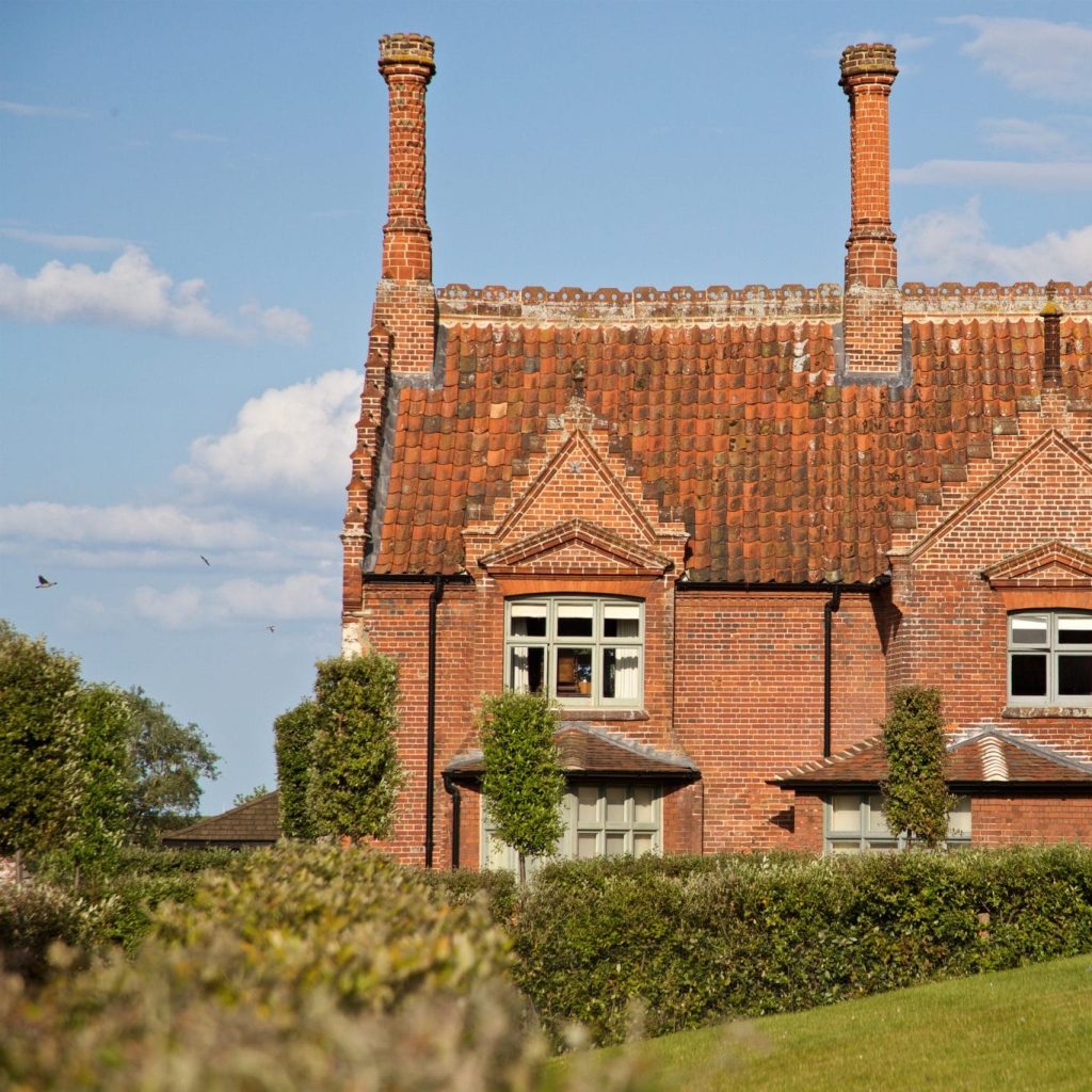 Exterior view of Ancient House, part of The Victoria hotel, a beautiful, historical brick building with tall chimneys